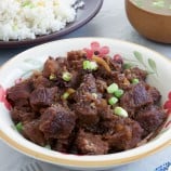 牛肉削皮放在盛菜的碗里，旁边放着一盘炒饭和肉汤gydF4y2Ba