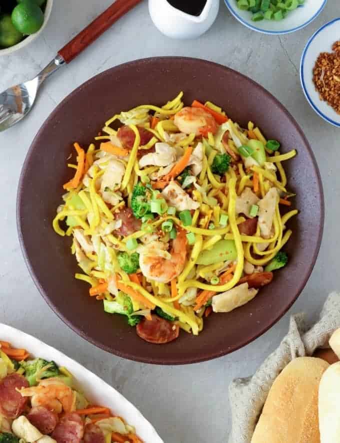 pancit lomi guisado在一盘上，侧面有pandesalGydF4y2Ba